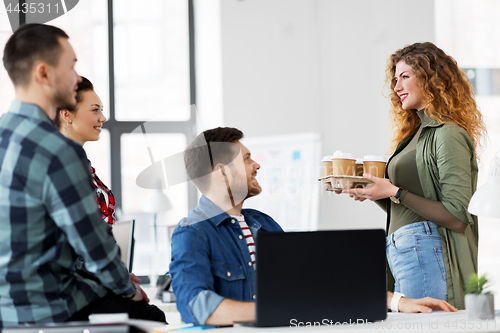 Image of happy creative team with coffee working at office