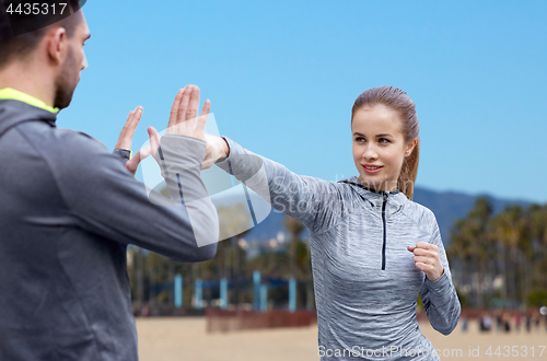 Image of happy woman with coach working on strike outdoors