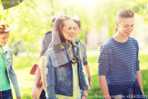 Image of group of happy teenage students walking outdoors