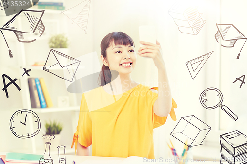 Image of asian woman student taking selfie with smartphone