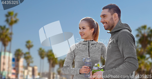 Image of couple of sportsmen with water over venice beach