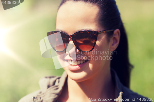 Image of face of happy young woman in sunglasses outdoors