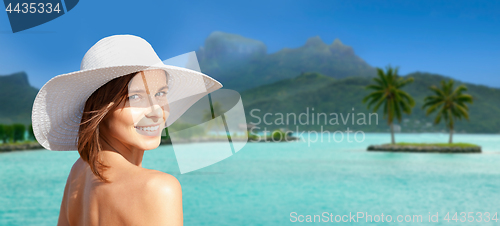 Image of happy woman in sun hat tanning on bora bora beach