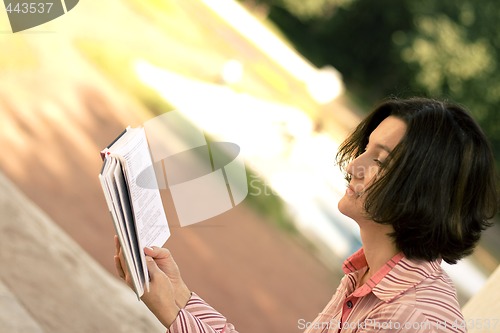 Image of  pretty woman reading in park