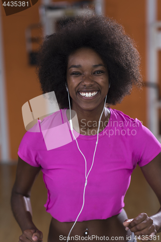 Image of afro american woman running on a treadmill