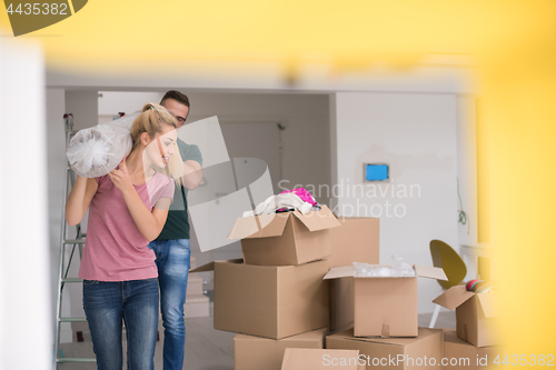 Image of couple carrying a carpet moving in to new home