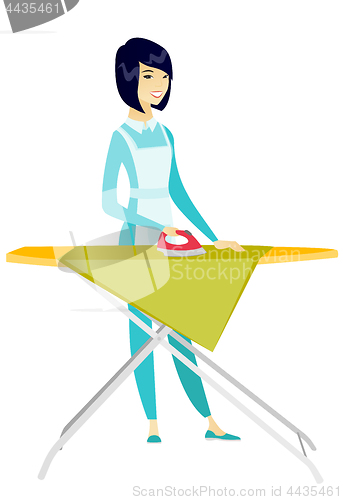 Image of Asian maid ironing clothes on ironing board.