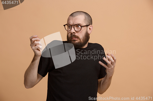 Image of Let me think. Doubtful pensive man with thoughtful expression making choice against pastel background