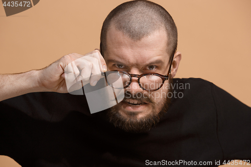 Image of The young emotional angry man on pastel studio background