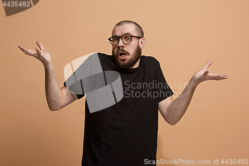Image of Beautiful male half-length portrait isolated on pastel studio backgroud. The young emotional surprised man