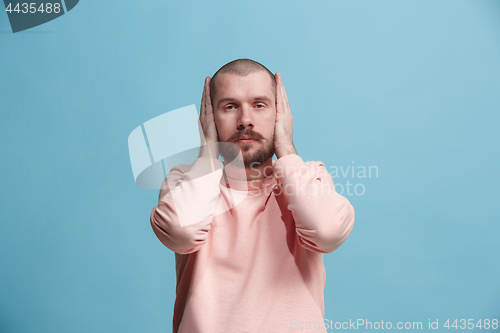 Image of Young man covering his ears and shouting.