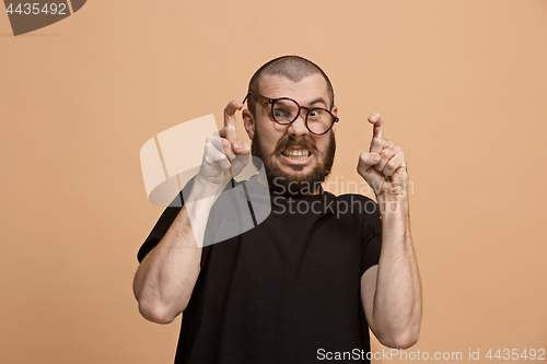 Image of The young emotional angry man on pastel studio background