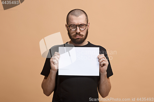 Image of A young man holds an empty plate in his hands to fill your text. Emotional, courageous face.