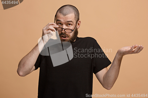 Image of Beautiful male half-length portrait isolated on pastel studio backgroud. The young emotional surprised man