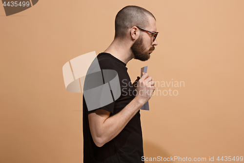 Image of A young man holds an empty plate in his hands to fill your text. Emotional, courageous face.