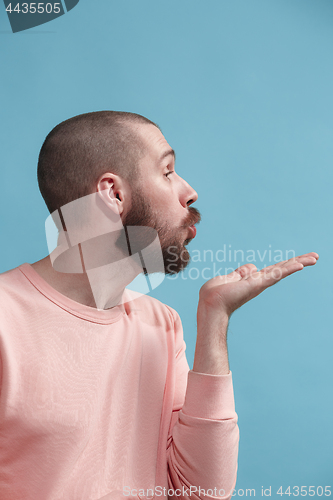 Image of Isolated on blue young casual man kissing at studio