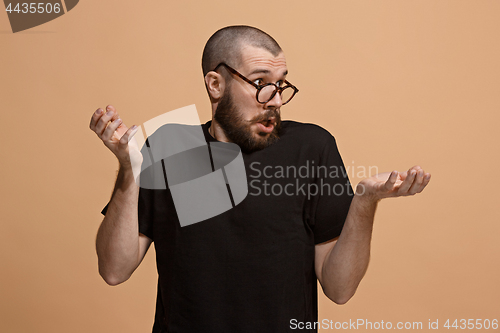 Image of Beautiful male half-length portrait isolated on pastel studio backgroud. The young emotional surprised man