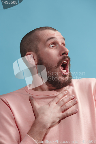 Image of Isolated on blue young casual man is afraid at studio