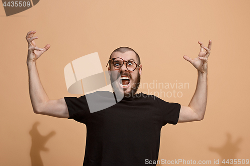 Image of The young emotional angry man on pastel studio background