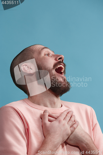 Image of Isolated on blue young casual man smiling and enjoying at studio