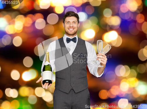 Image of man with bottle of champagne and glasses at party