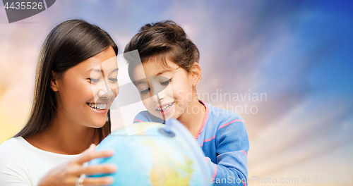 Image of happy mother and daughter with globe over sky