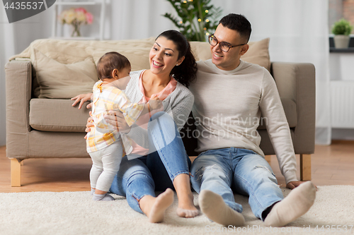 Image of happy family with baby daughter at home