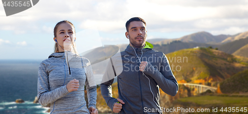 Image of couple with earphones running over big sur coast