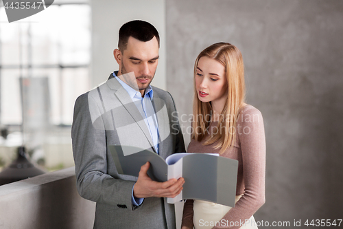 Image of businesswoman and businessman with folder