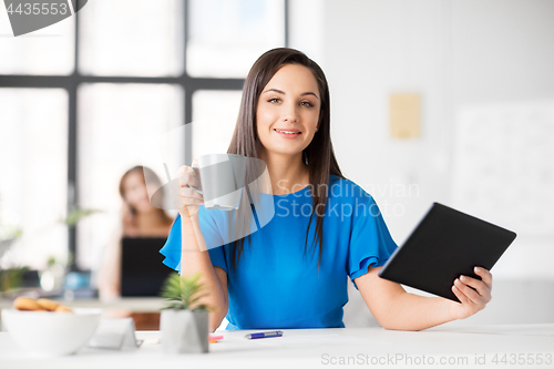 Image of businesswoman with tablet pc and coffee at office