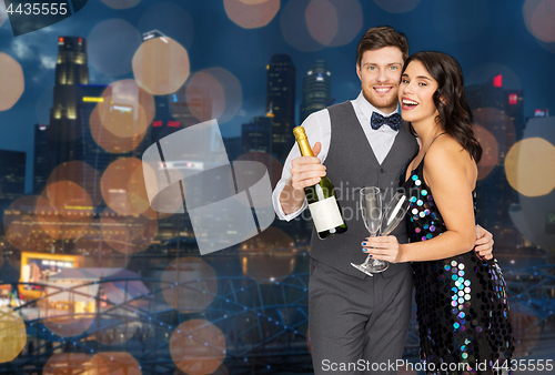 Image of happy couple with champagne and glasses at party