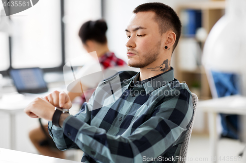 Image of creative man with smart watch working at office