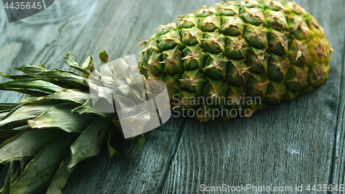 Image of Half of pineapple on wooden table