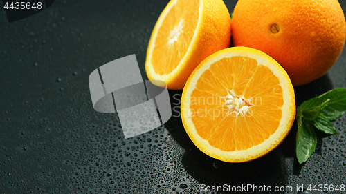 Image of Orange with leaf on wet table 