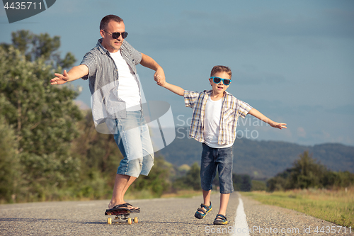 Image of Father and son playing on the road at the day time.