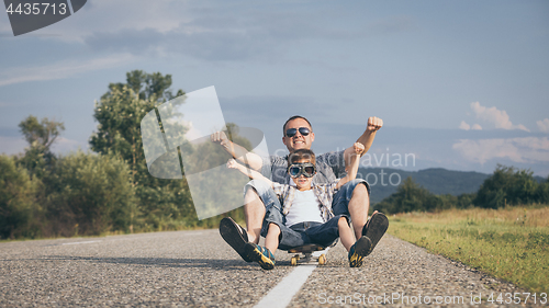 Image of Father and son playing on the road at the day time.