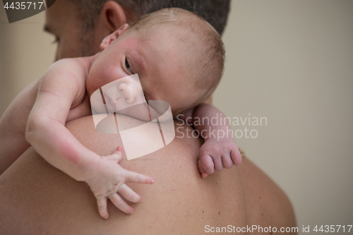 Image of Father holding newborn baby son at the day time