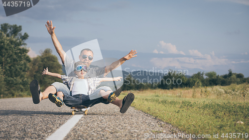 Image of Father and son playing on the road at the day time.