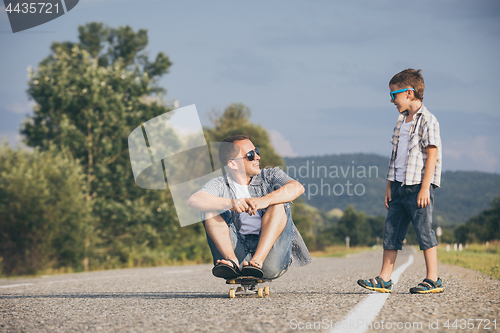 Image of Father and son playing on the road at the day time.