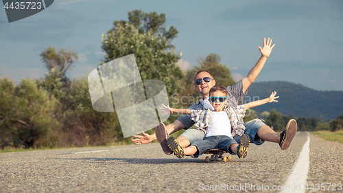 Image of Father and son playing on the road at the day time.