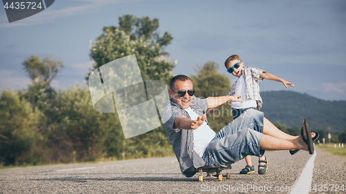 Image of Father and son playing on the road at the day time.