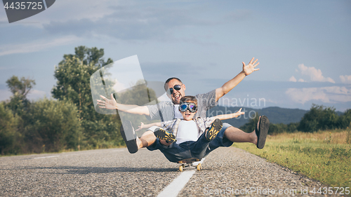 Image of Father and son playing on the road at the day time.