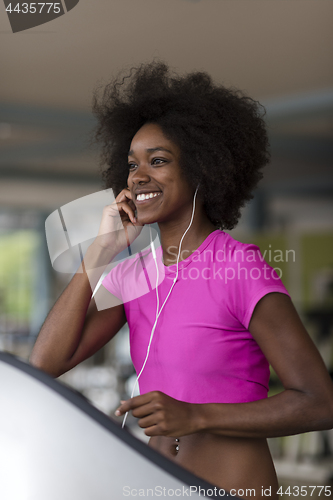 Image of afro american woman running on a treadmill