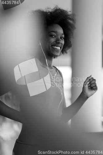 Image of afro american woman running on a treadmill