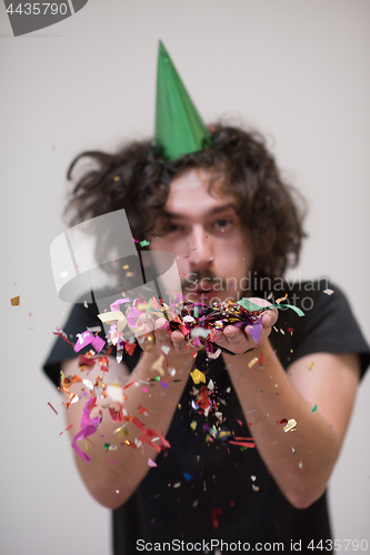 Image of man blowing confetti in the air