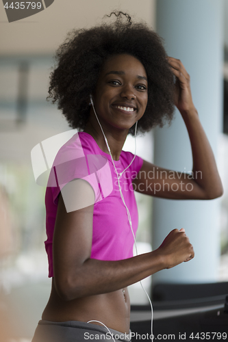 Image of afro american woman running on a treadmill