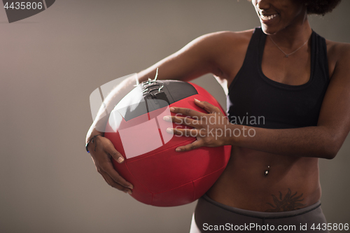 Image of black woman carrying crossfit ball