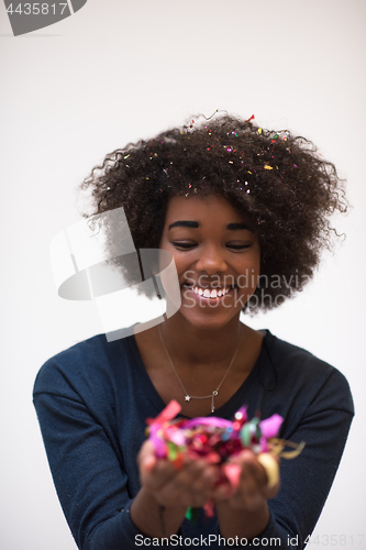 Image of African American woman blowing confetti in the air