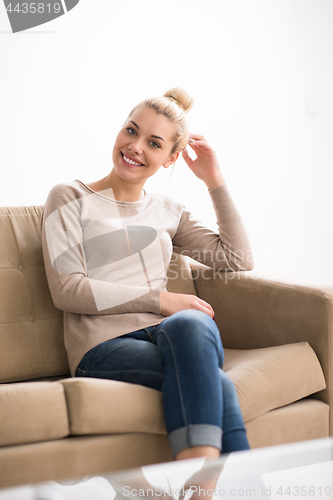 Image of woman sitting on sofa with tablet computer
