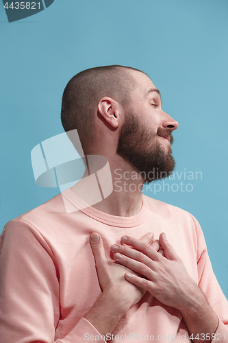 Image of Isolated on blue young casual man smiling and enjoying at studio